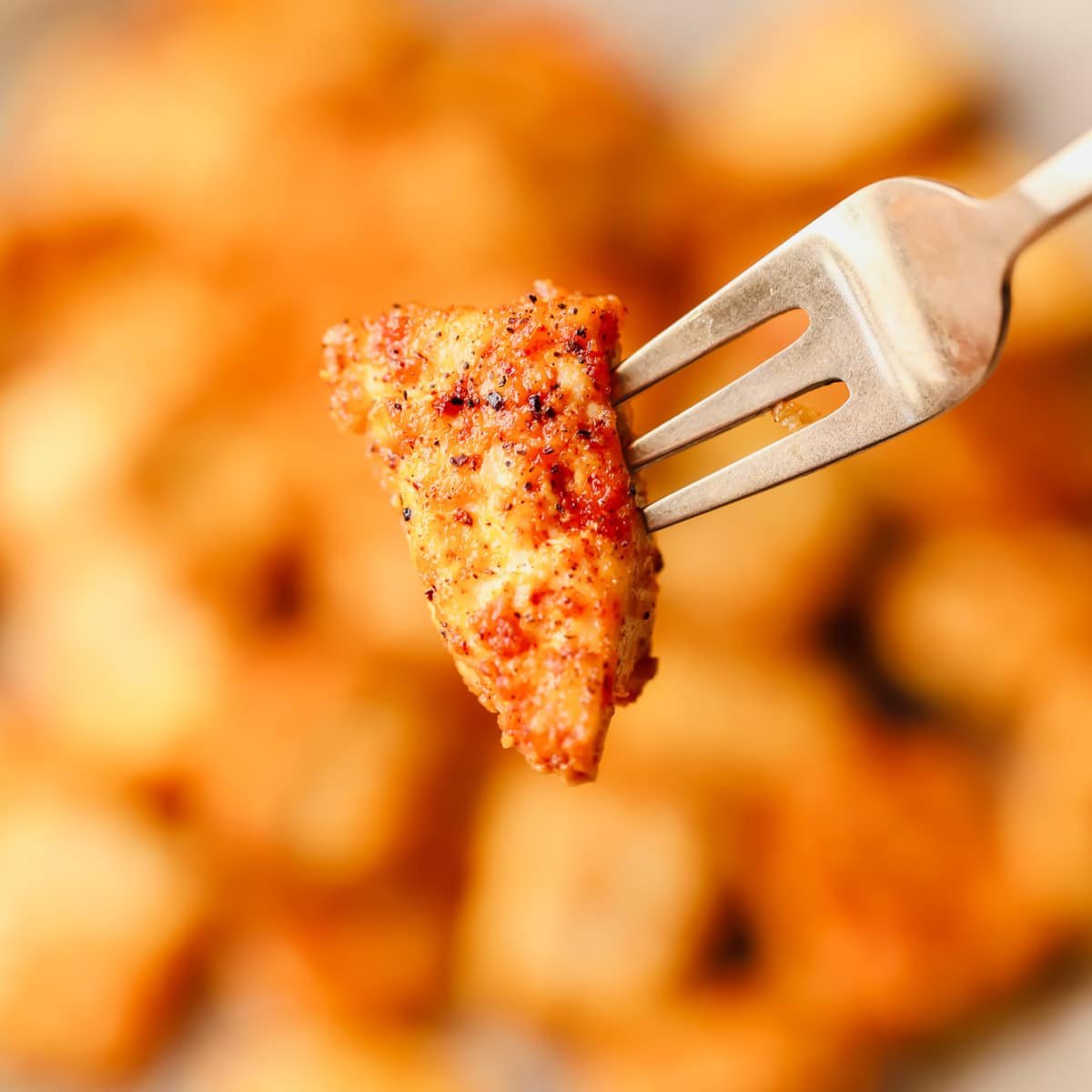 close up on a piece of crispy baked tofu on a metal fork.