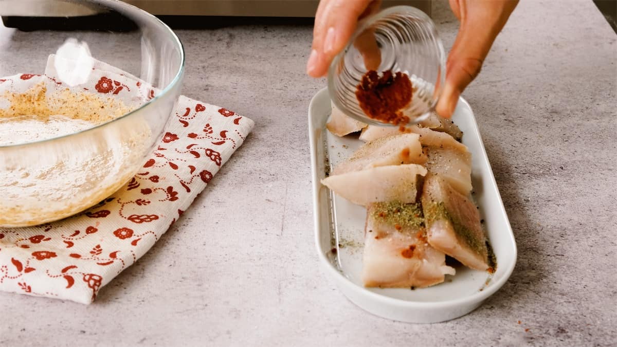 Feyza adds seasoning to the fish prior to coating in the batter