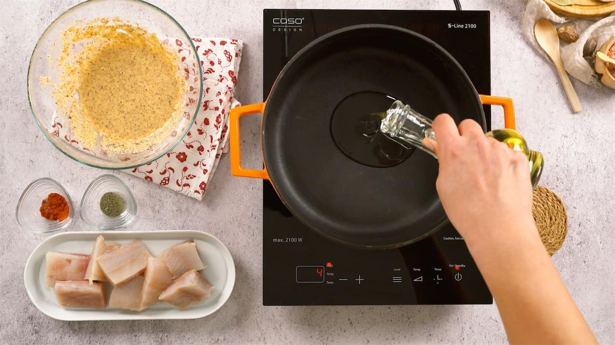 Feyza heating oil on a stove top.