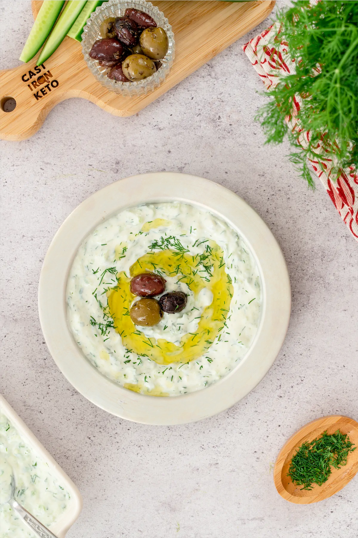 A visually appealing keto tzatziki recipe including olives, showcased on a white plate.