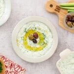 homemade keto tzatziki recipe with olive, white plate, cutting board