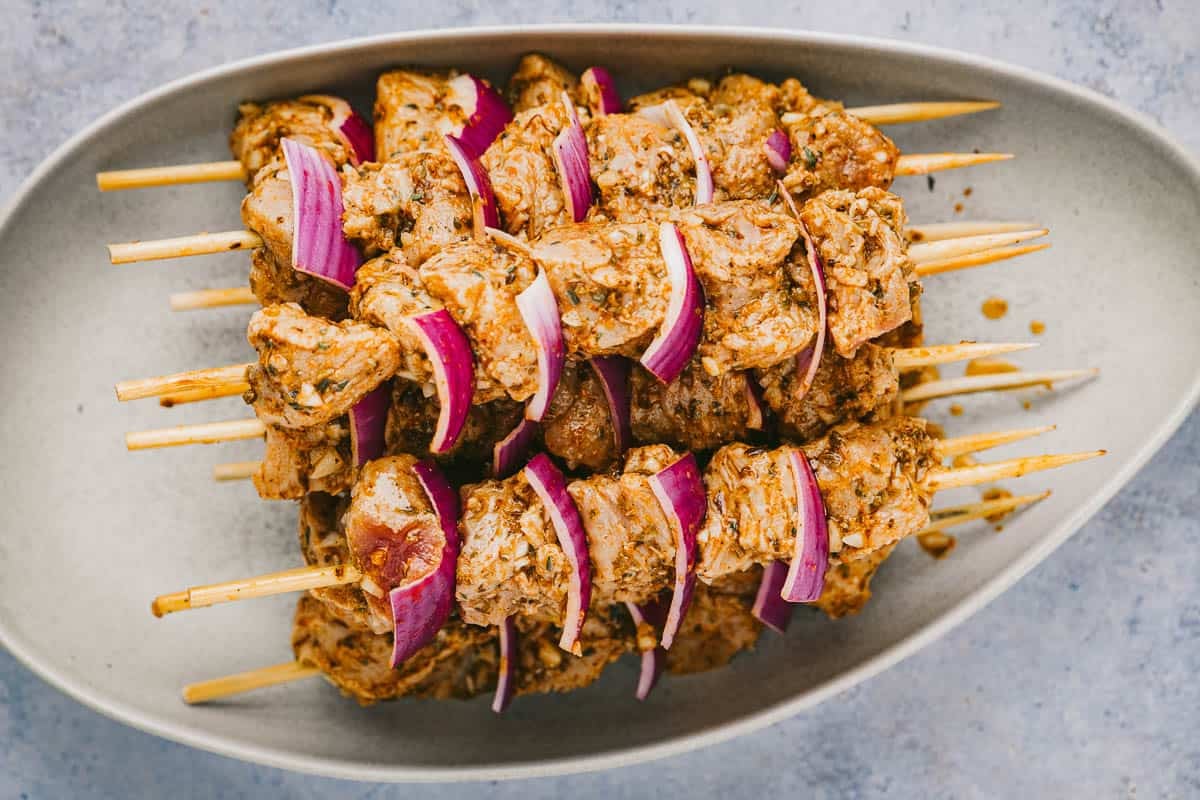 Marinated pork souvlaki skewers with red onion.