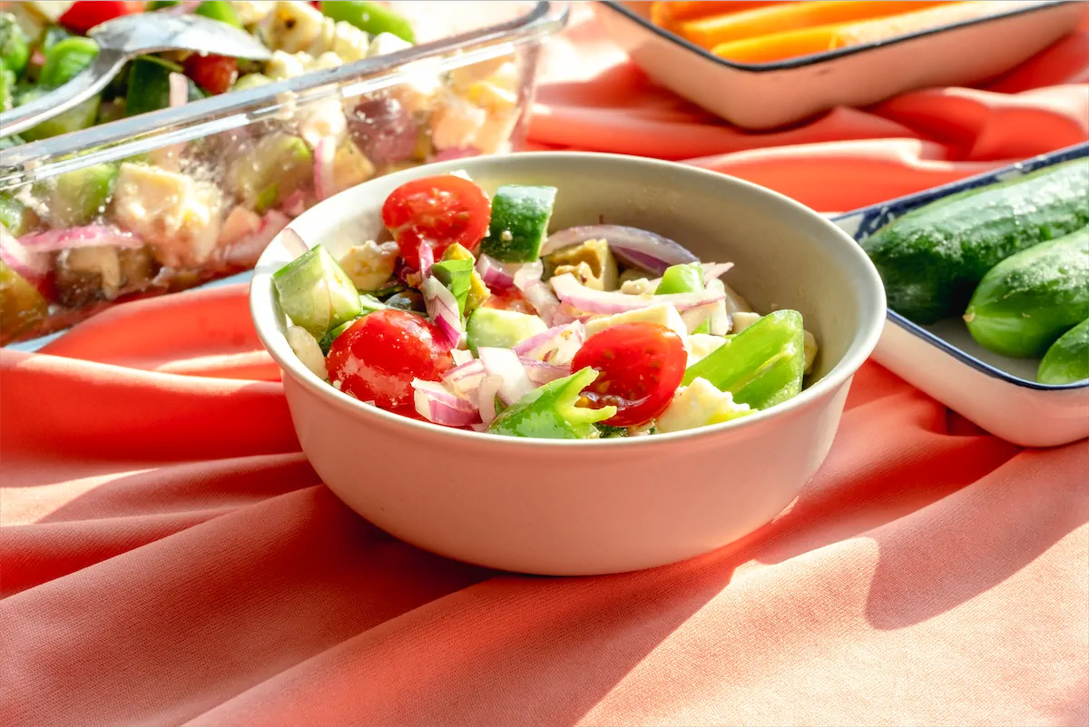 Keto Greek Salad featuring chopped tomatoes, onions, cucumber and other ingredients.