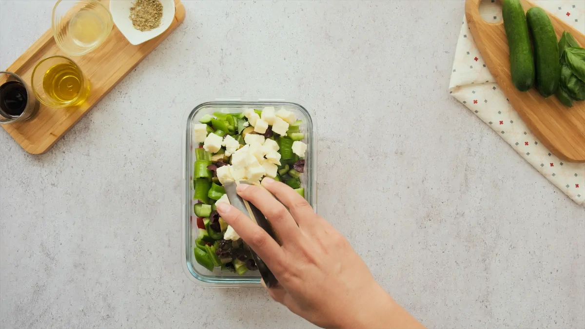 Adding feta cheese to the salad.