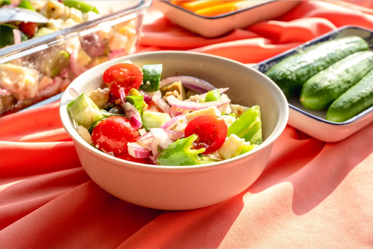 Keto salad containing tomatoes, onions, olives, and feta cheese.