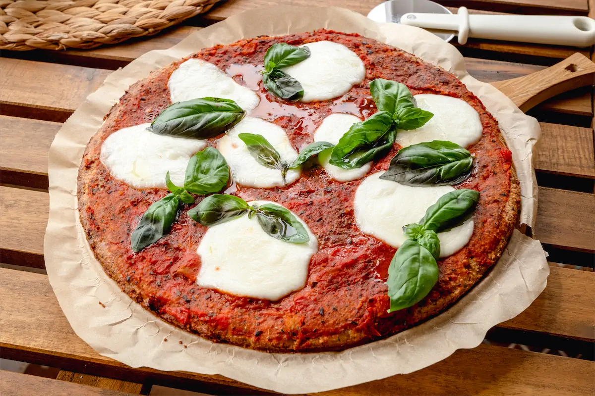 Freshly baked keto pizza recipe on kitchen table.