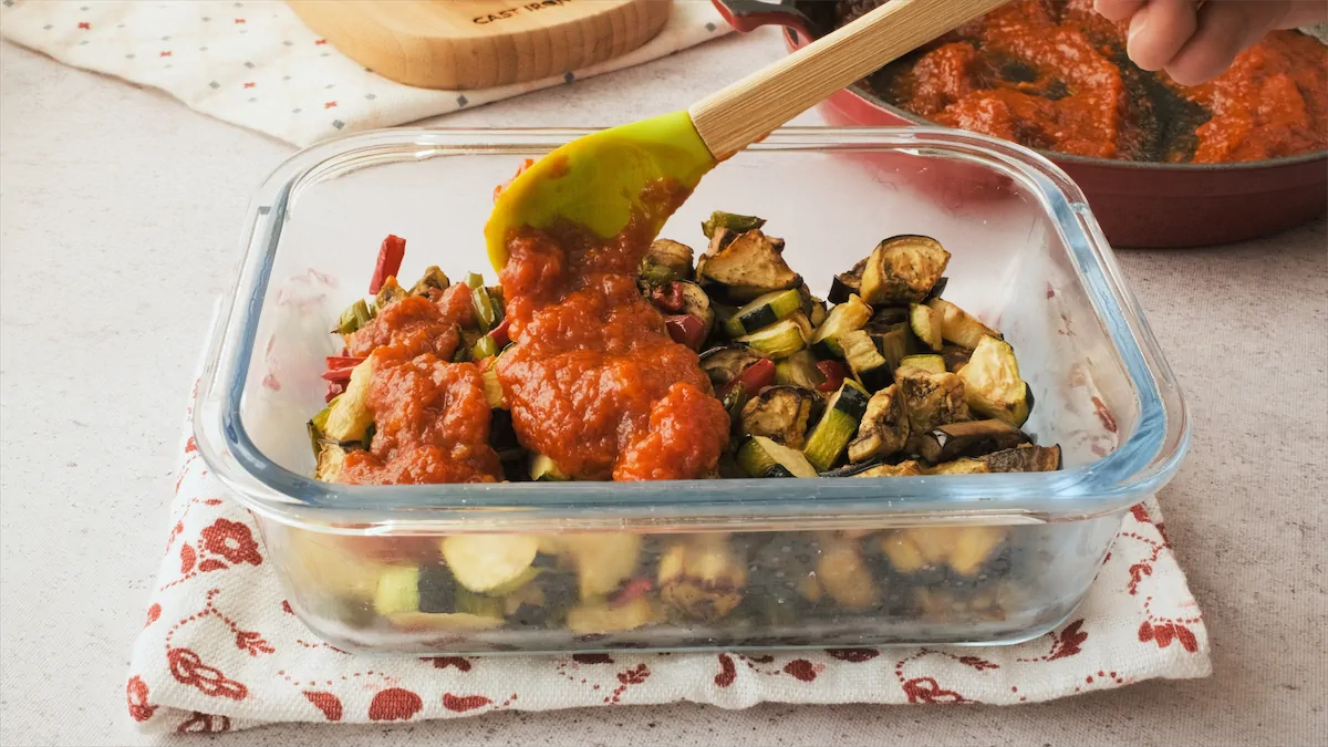 Topping air fried eggplant, zucchini, and bell peppers with tomato sauce.