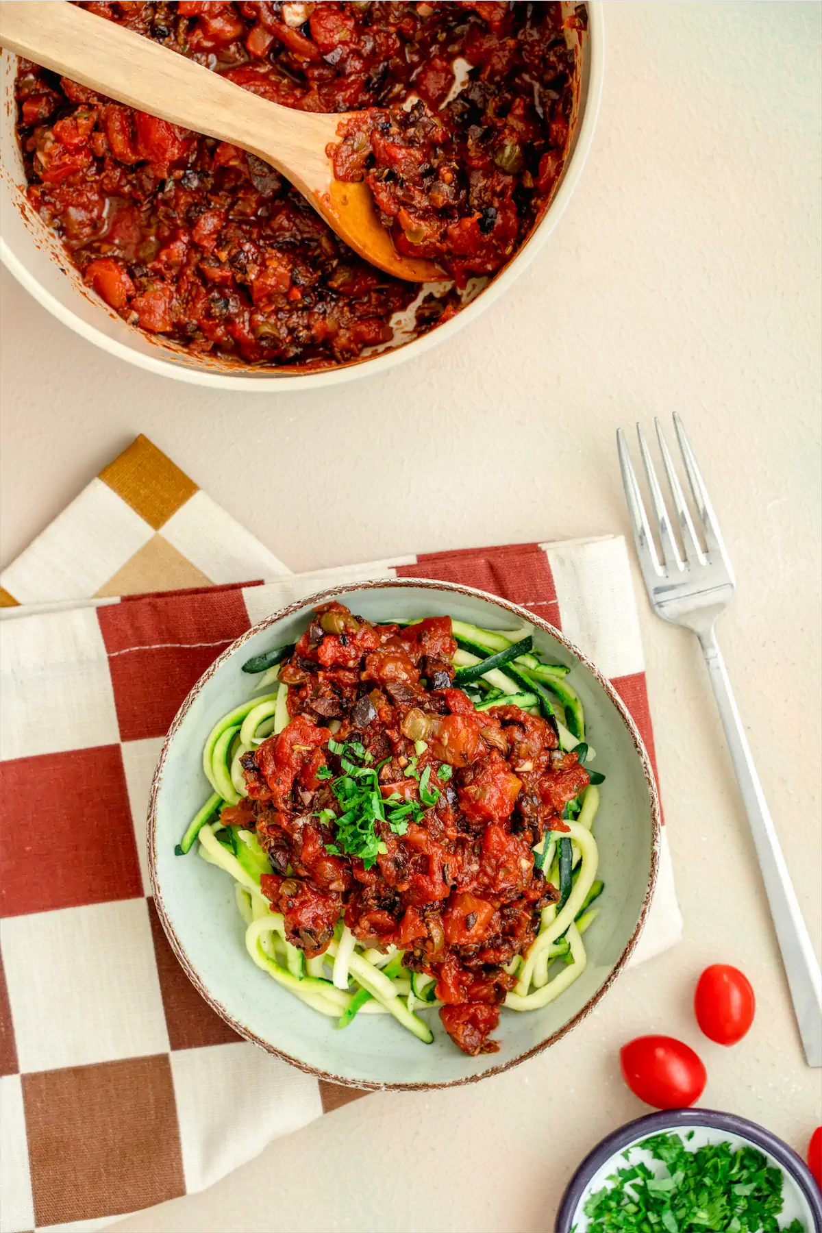 A plate of zucchini noodles topped with puttanesca sauce.