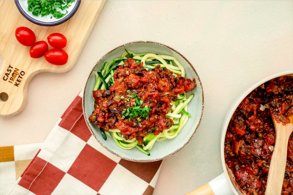 Keto Puttanesca Sauce served on top of Zucchini Noodles in a bowl.