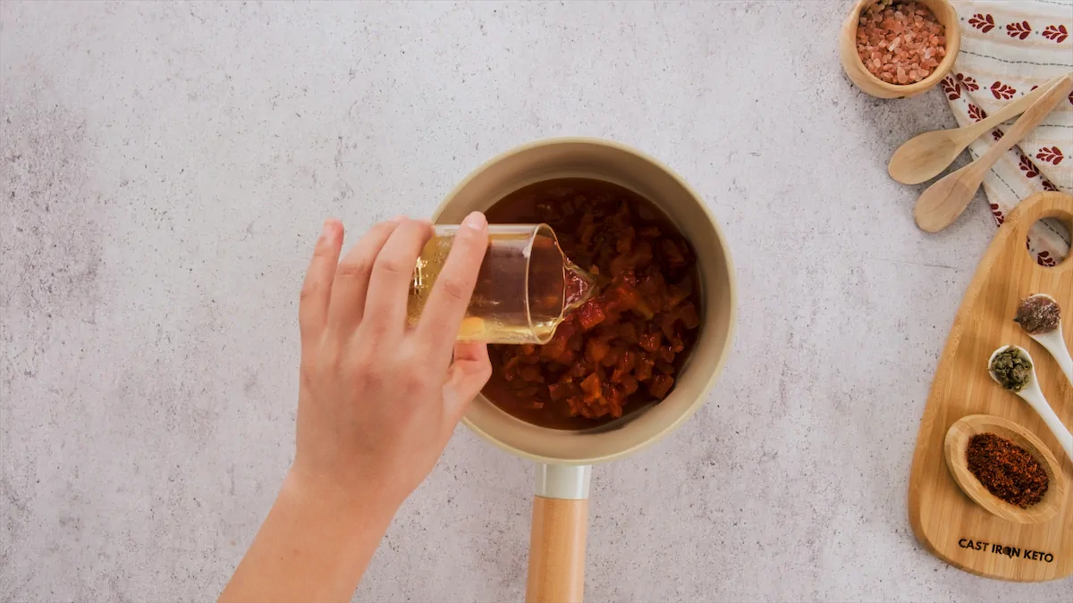 Adding dry white wine with chopped tomatoes in a saucepan.