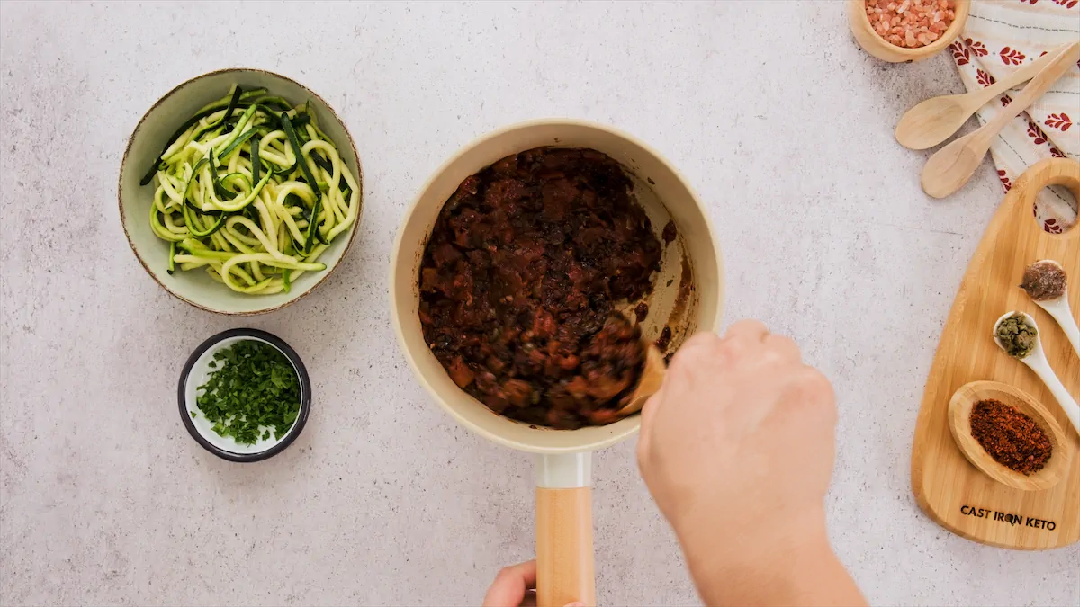 Combining the mixture of tomatoes with rest of the ingredients.