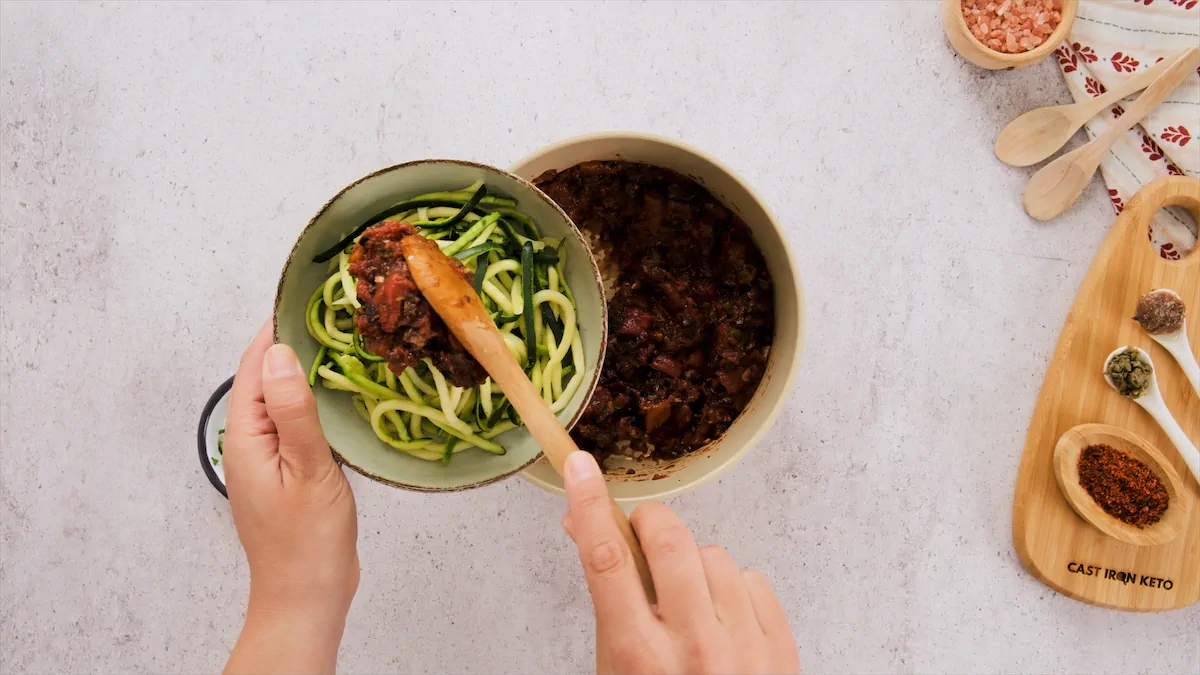 Topping keto zucchini noodles with keto puttanesca sauce.