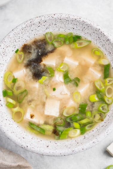 Miso soup with tofu in white bowls, vegan, close up