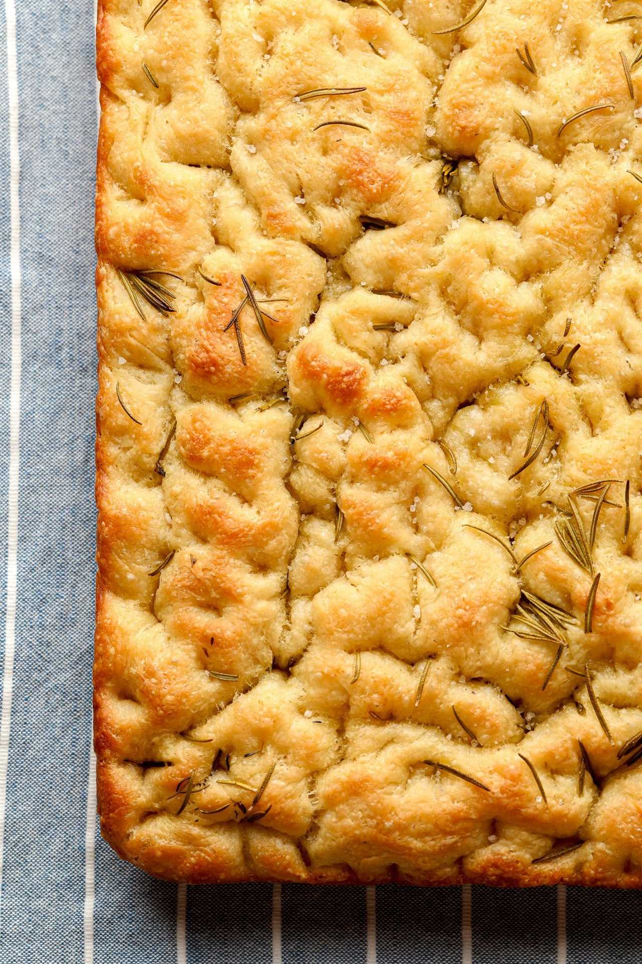 close up on baked vegan focaccia with rosemary and salt on top.