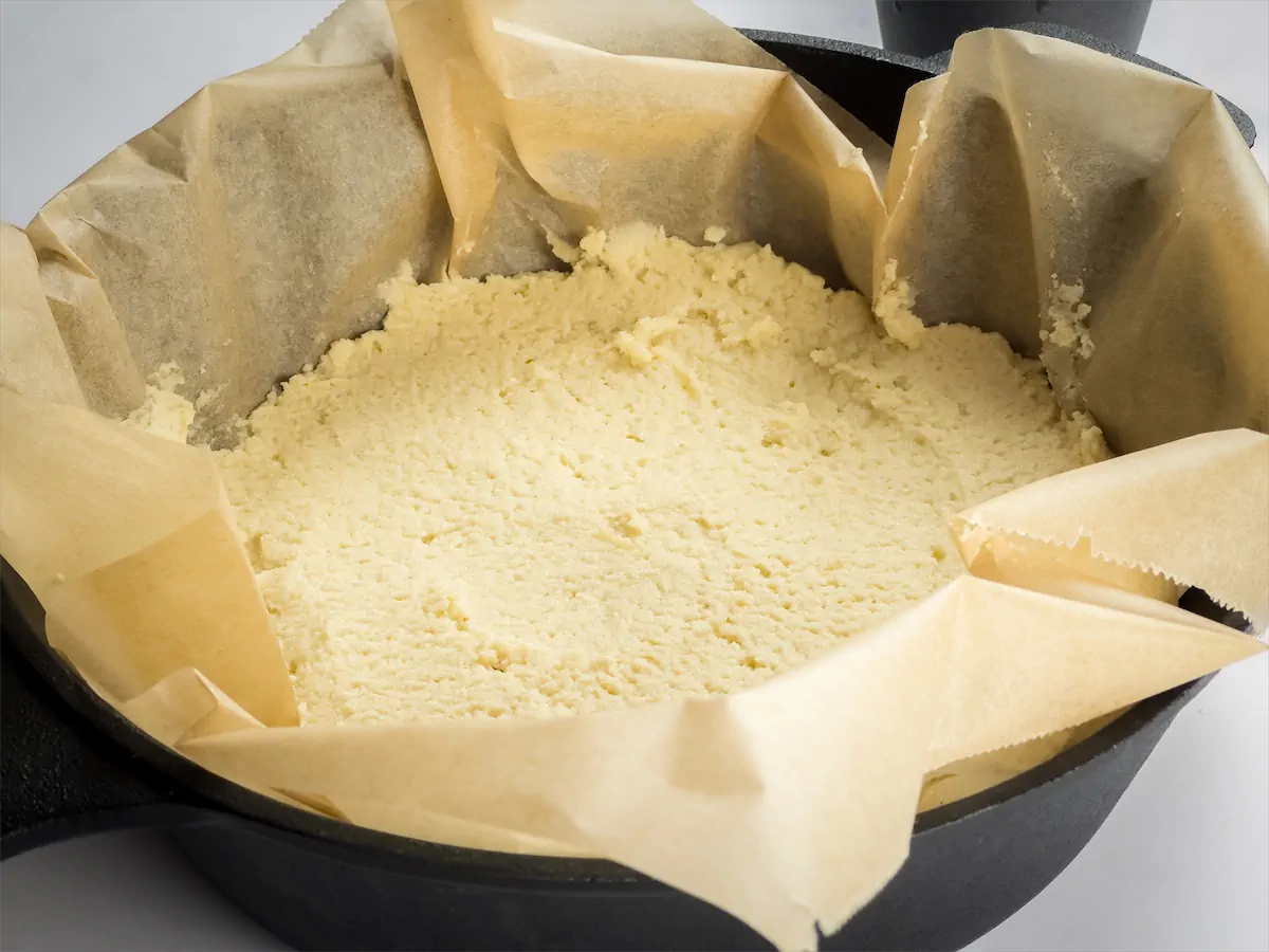 The batter evenly spread in the Dutch oven lined with parchment paper.