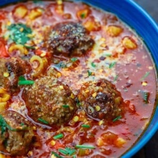 Meatball soup served in a bowl and garnished with parsley