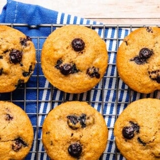 6 blueberry muffins on a cooling rack.