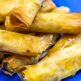 close up of sigara boregi rolls on a blue plate.