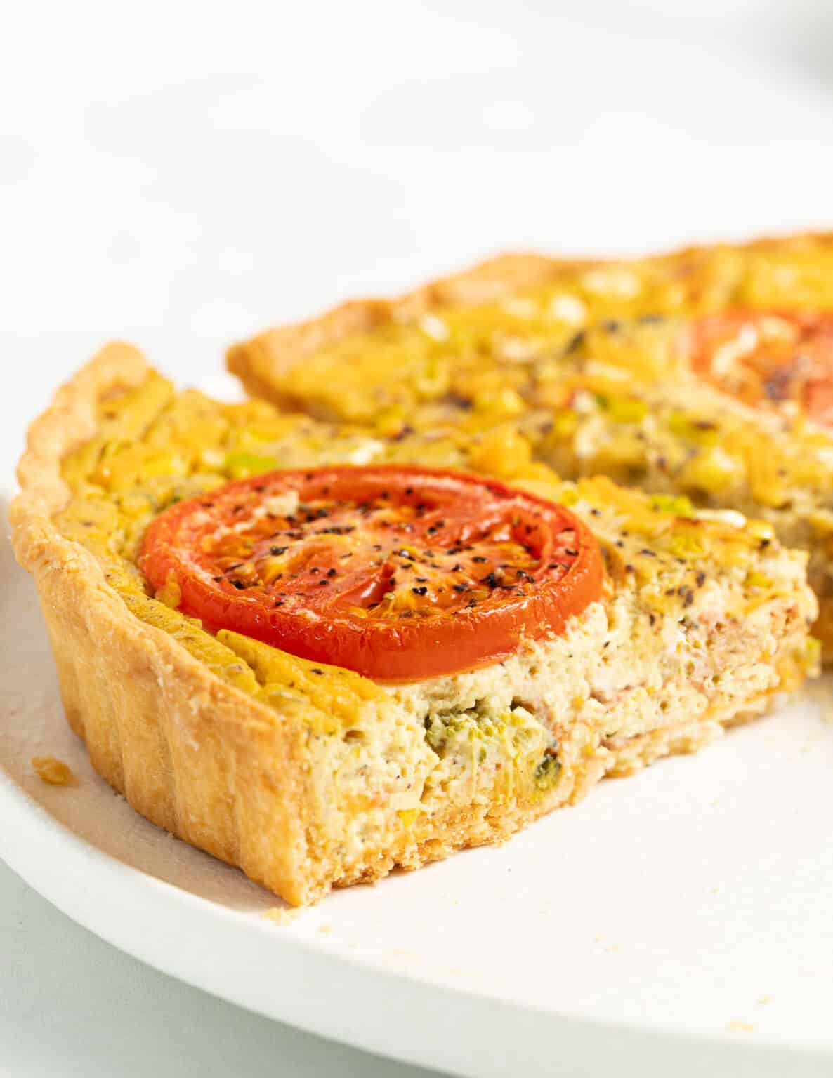 vegan quiche slices with tomato on top on a plate