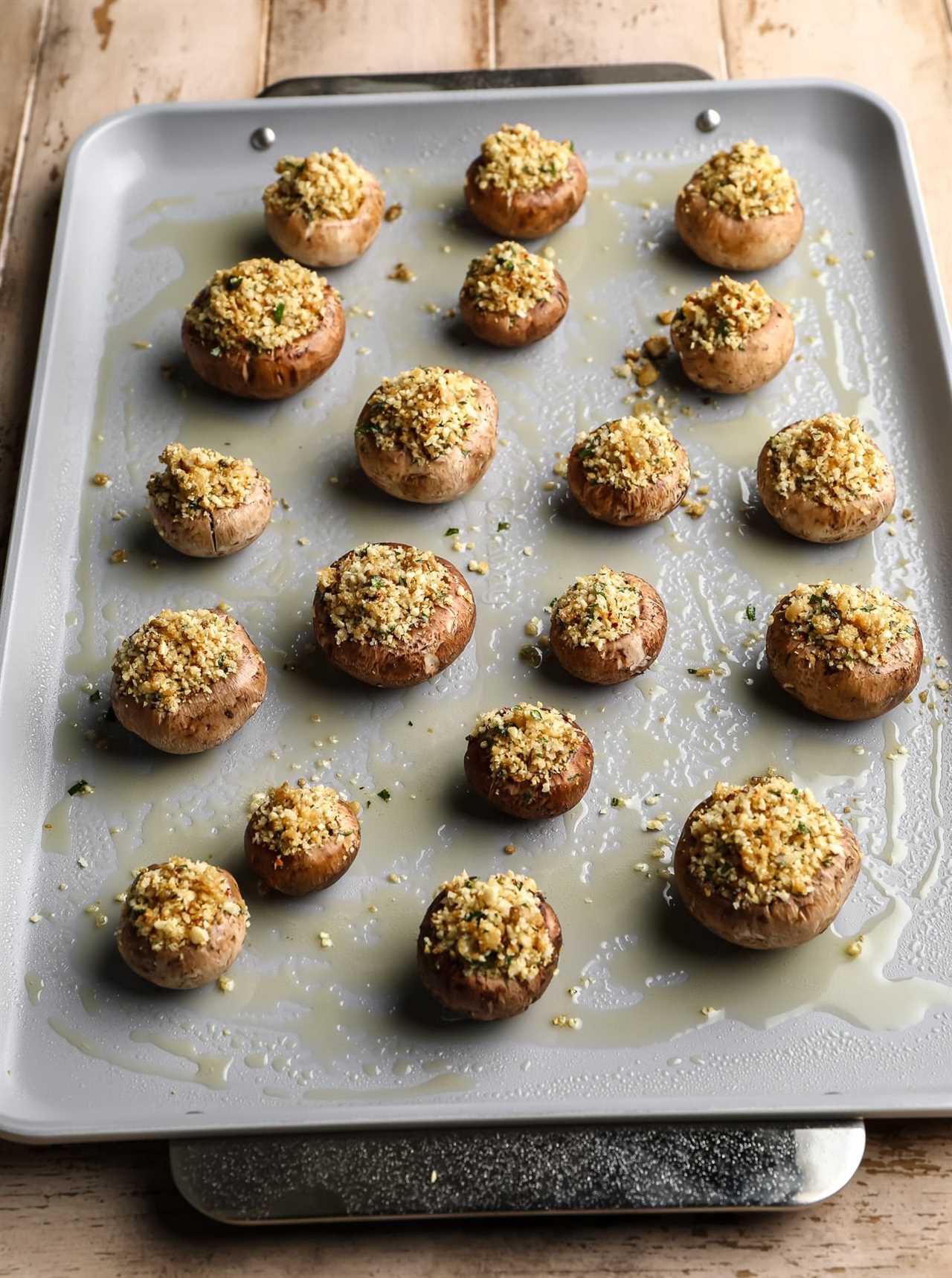 rows of vegan stuffed mushrooms on a greased baking sheet.