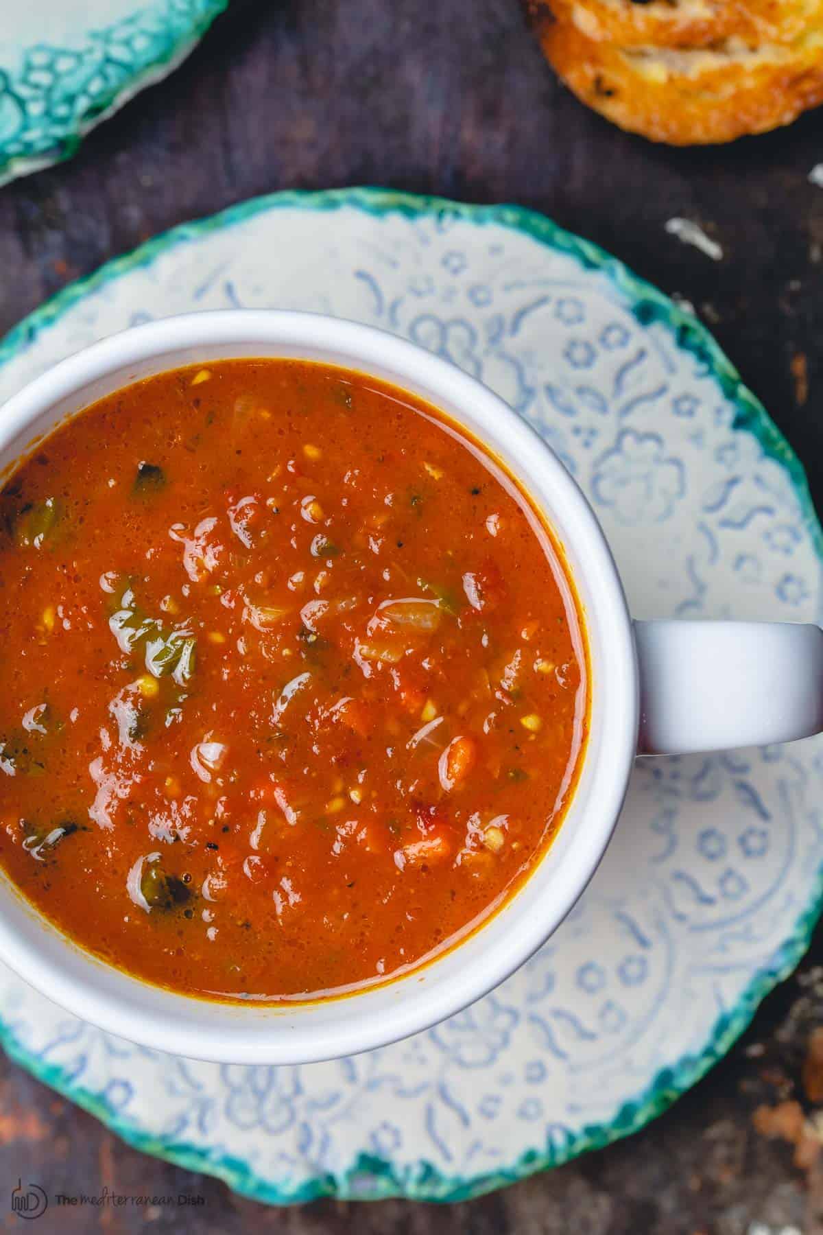 tomato basil soup served in a bowl with a side of crusty bread