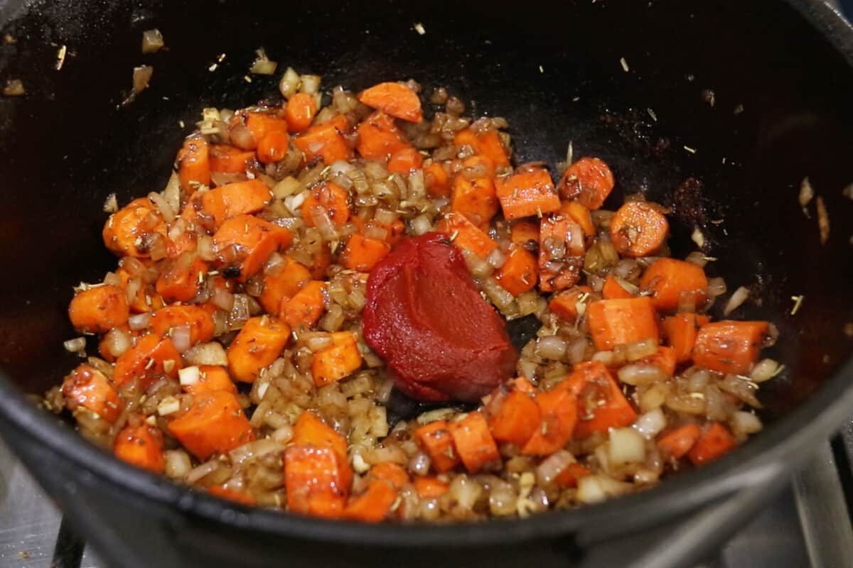 step by step - tomato paste being added into carrots, onions and spices