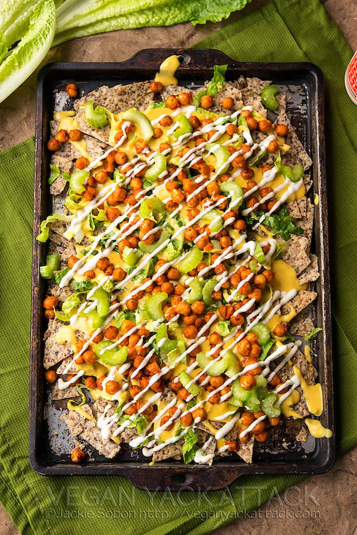 Vegan buffalo chickpea nachos on a baking sheet.