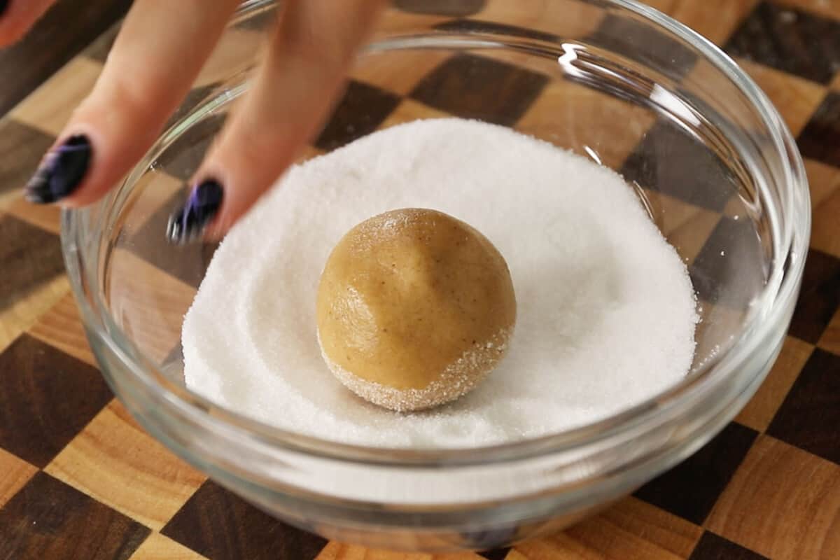 balls of dough being rolled in sugar