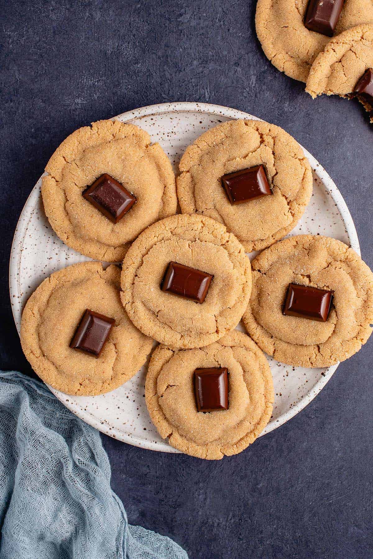 peanut butter blossoms on white plate with blue napkin