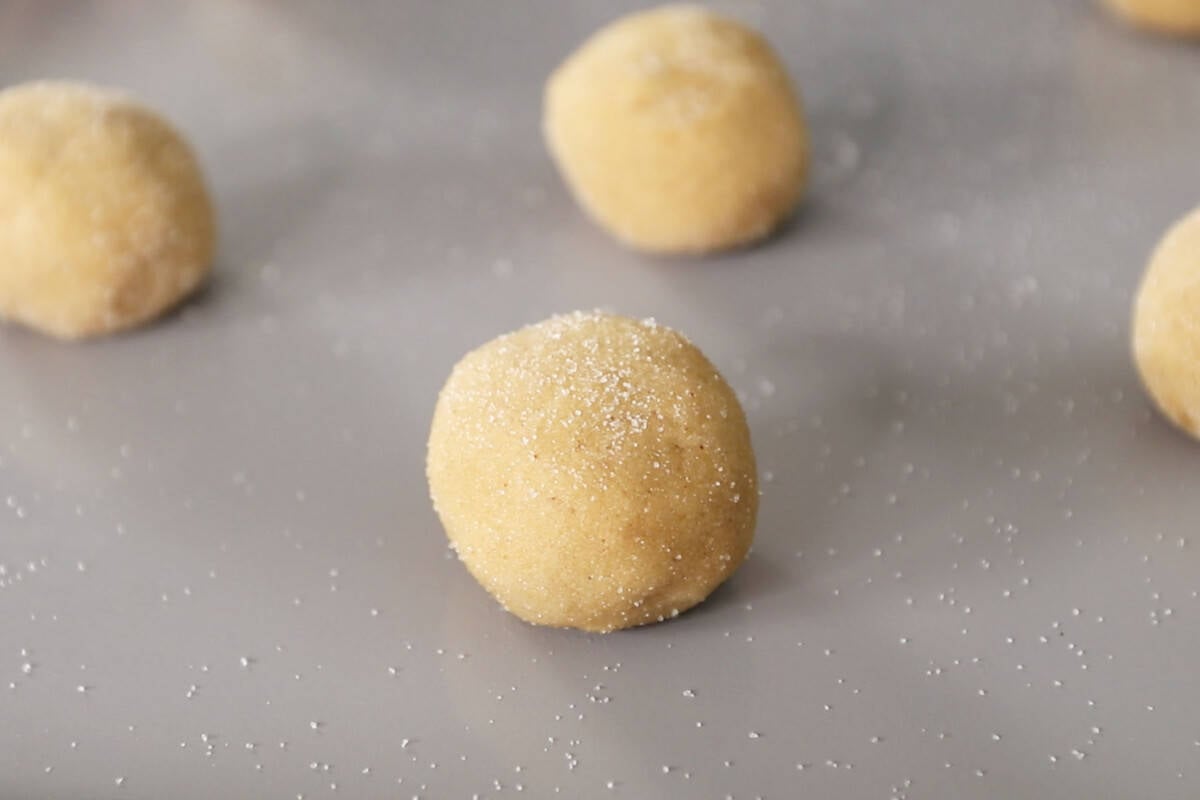 cookie balls on a baking sheet before going into the oven