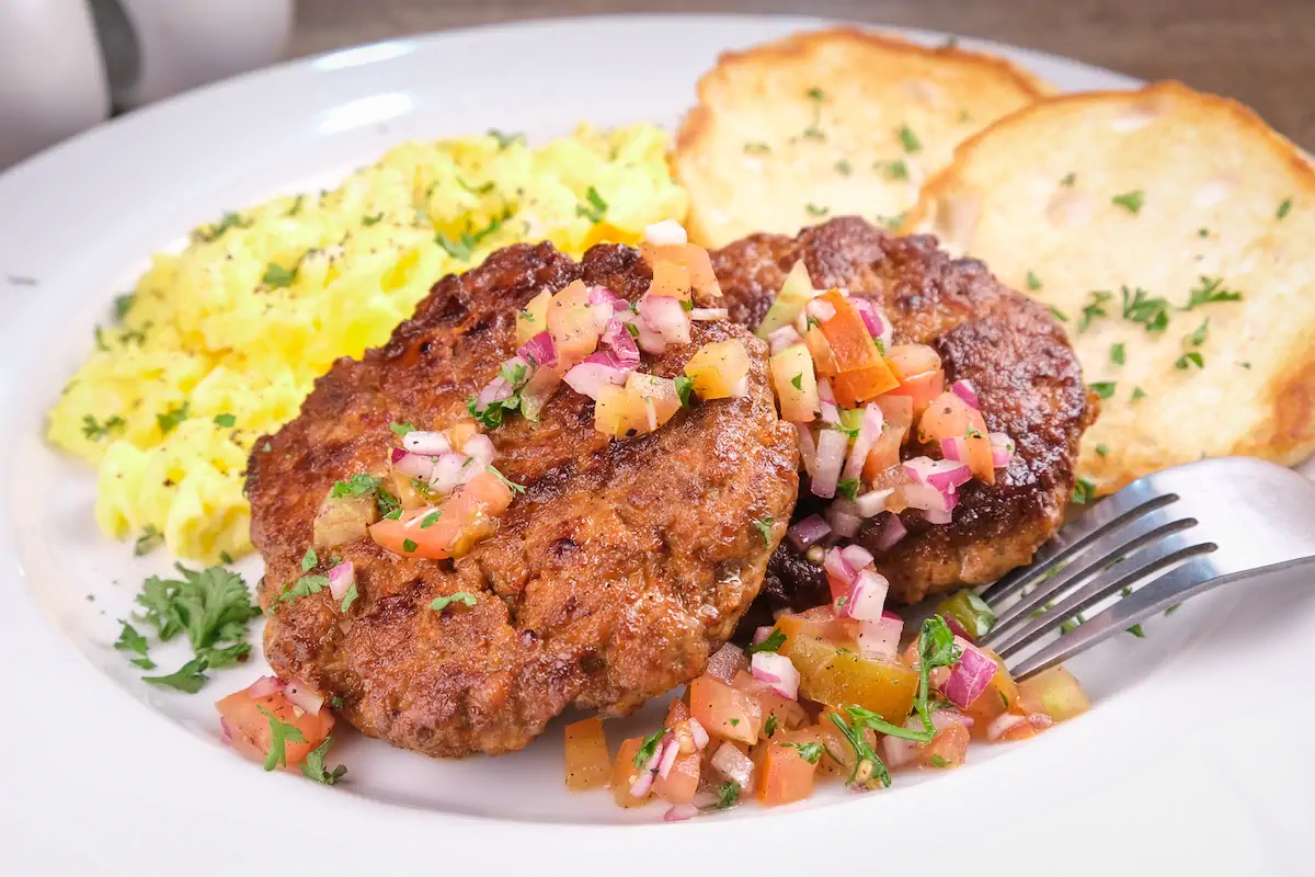 Keto breakfast sausage served with sides of keto bread and scrambled eggs.