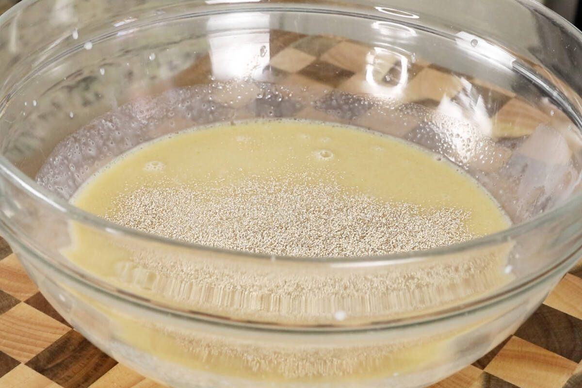 making ube cinnamon roll dough in glass bowl