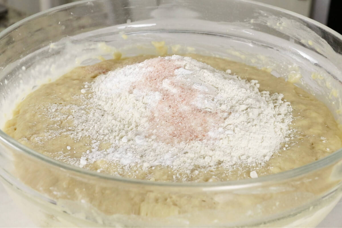 making ube cinnamon roll dough in glass bowl