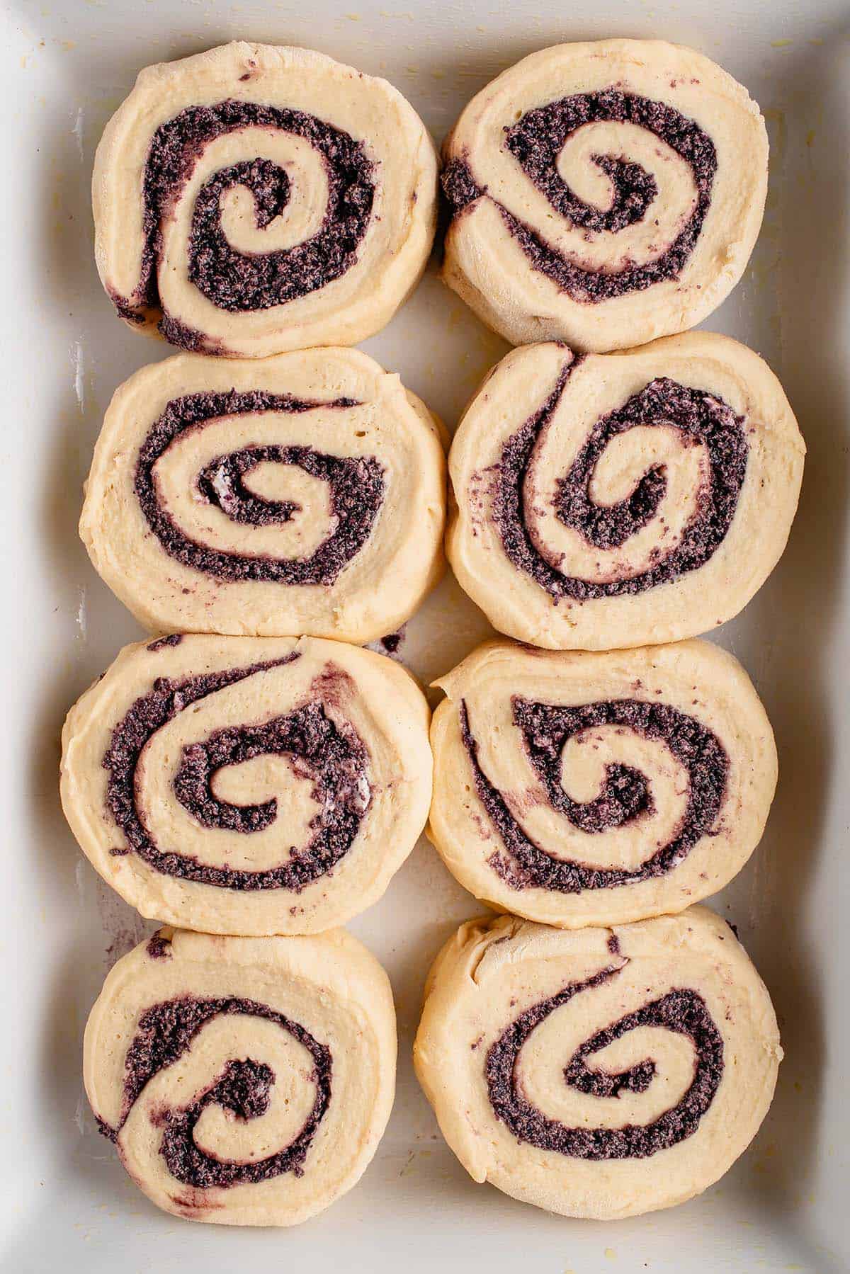 unbaked ube cinnamon rolls in white dish 