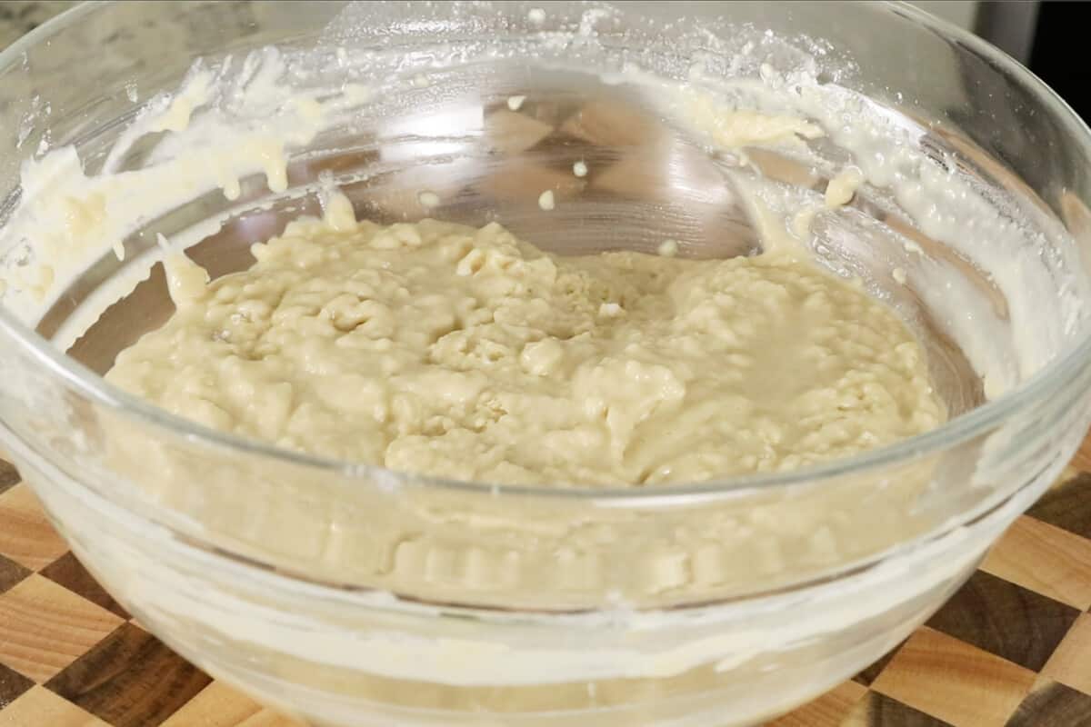 making ube cinnamon roll dough in glass bowl