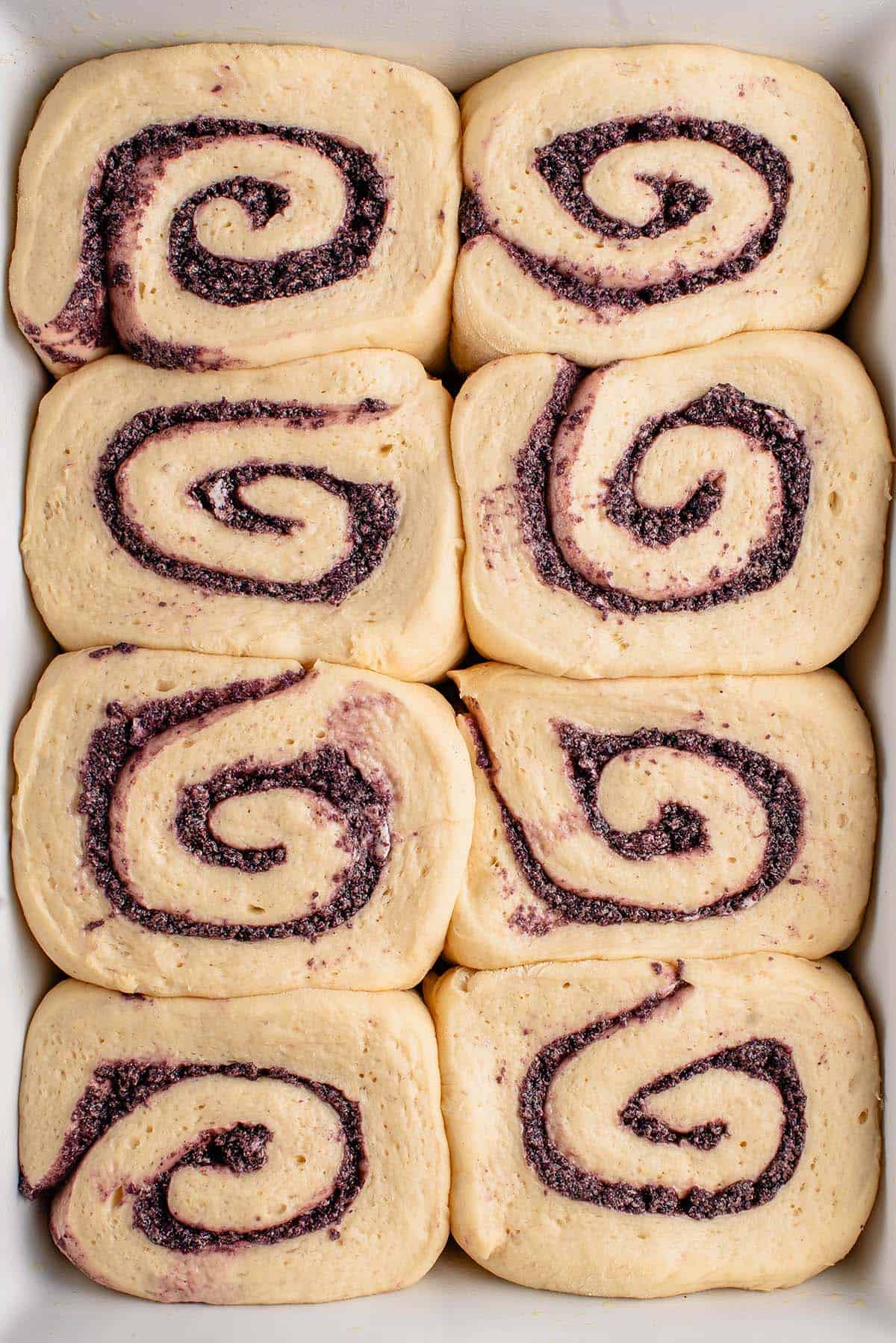 unbaked ube cinnamon rolls in white dish 