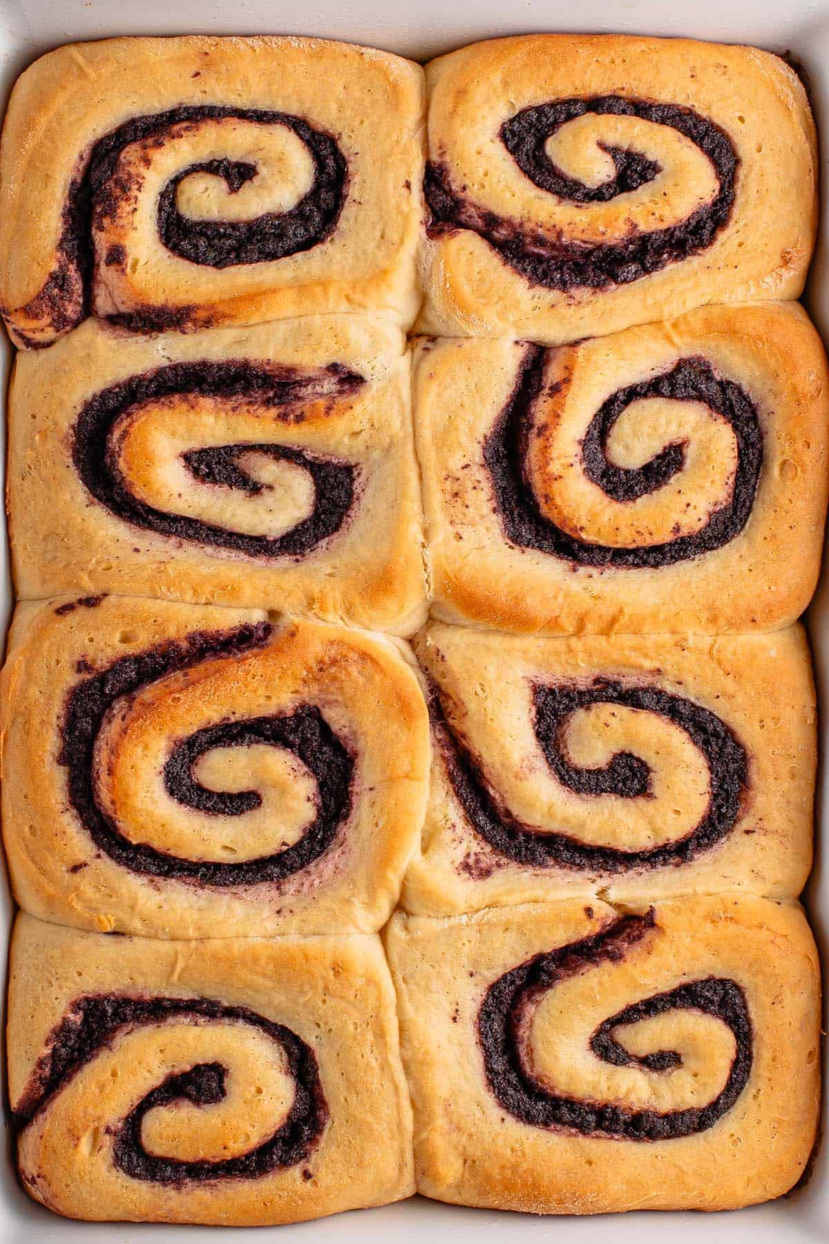 baked ube cinnamon rolls in white dish 