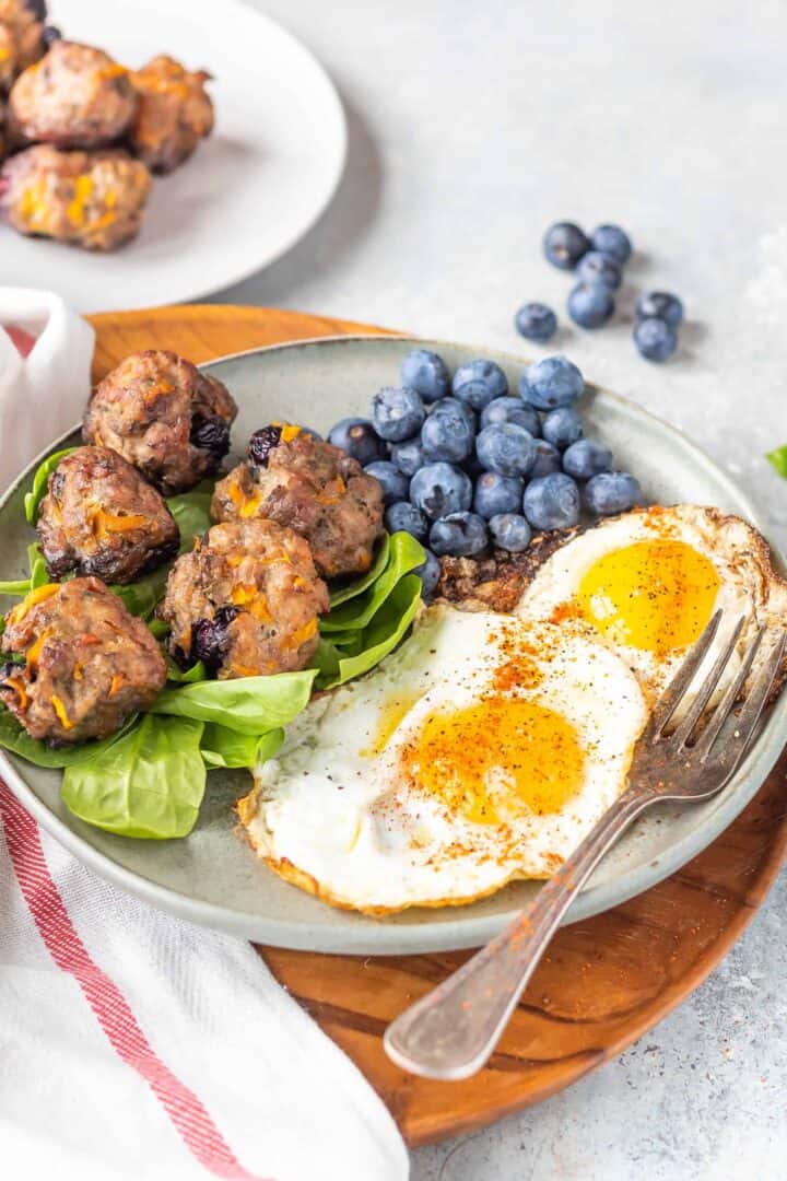 Keto Breakfast Meatballs on plate with eggs and blueberries