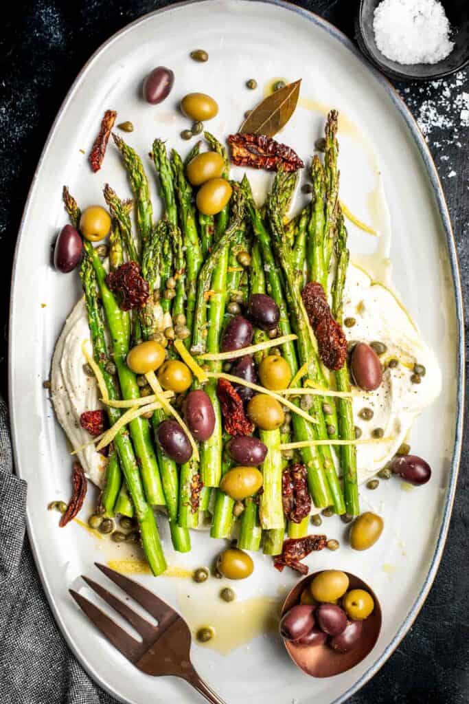 Mediterranean Asparagus - charred lemon garlic asparagus on top of whipped feta and topped with olives, capers, sun-dried tomatoes, and lemon zest.