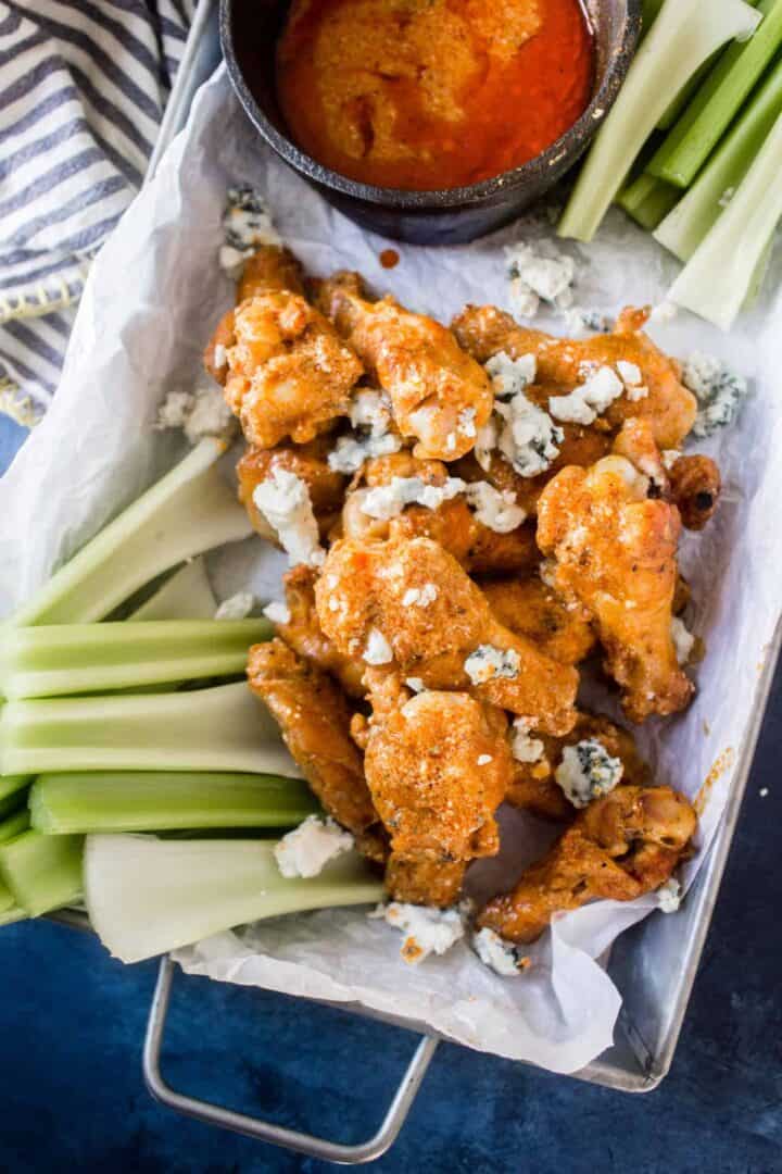 keto chicken wings in tray with buffalo blue cheese sauce and celery