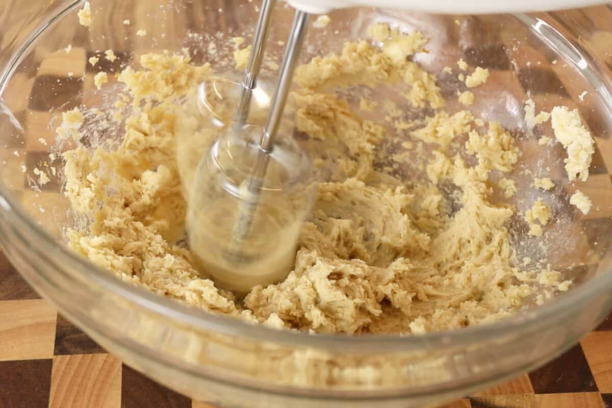 butter and sugar being creamed together with a hand mixer