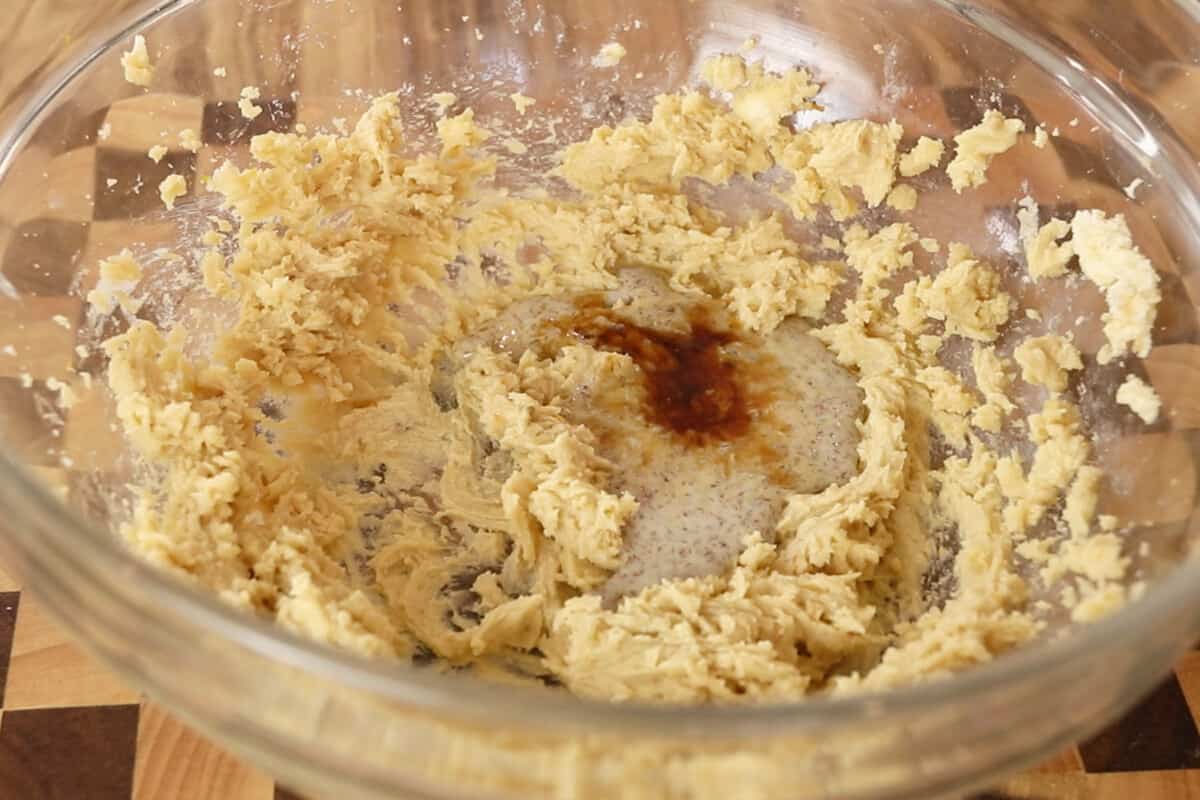 vanilla and flaxseed egg being added to creamed butter and sugar mixture