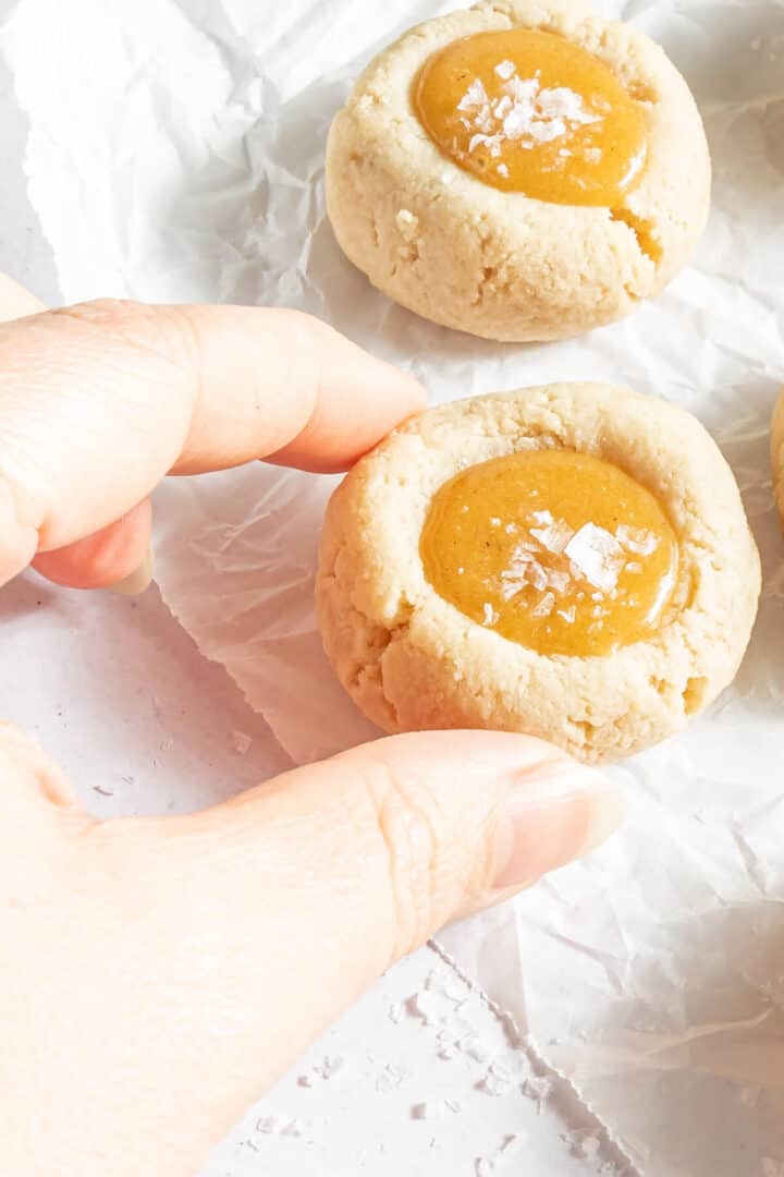 a hand picking up a single cookie