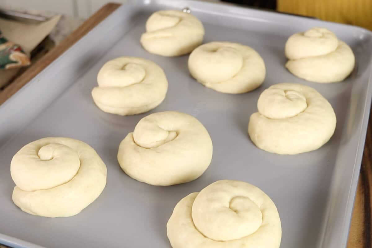 unbaked ensaymada on baking sheet