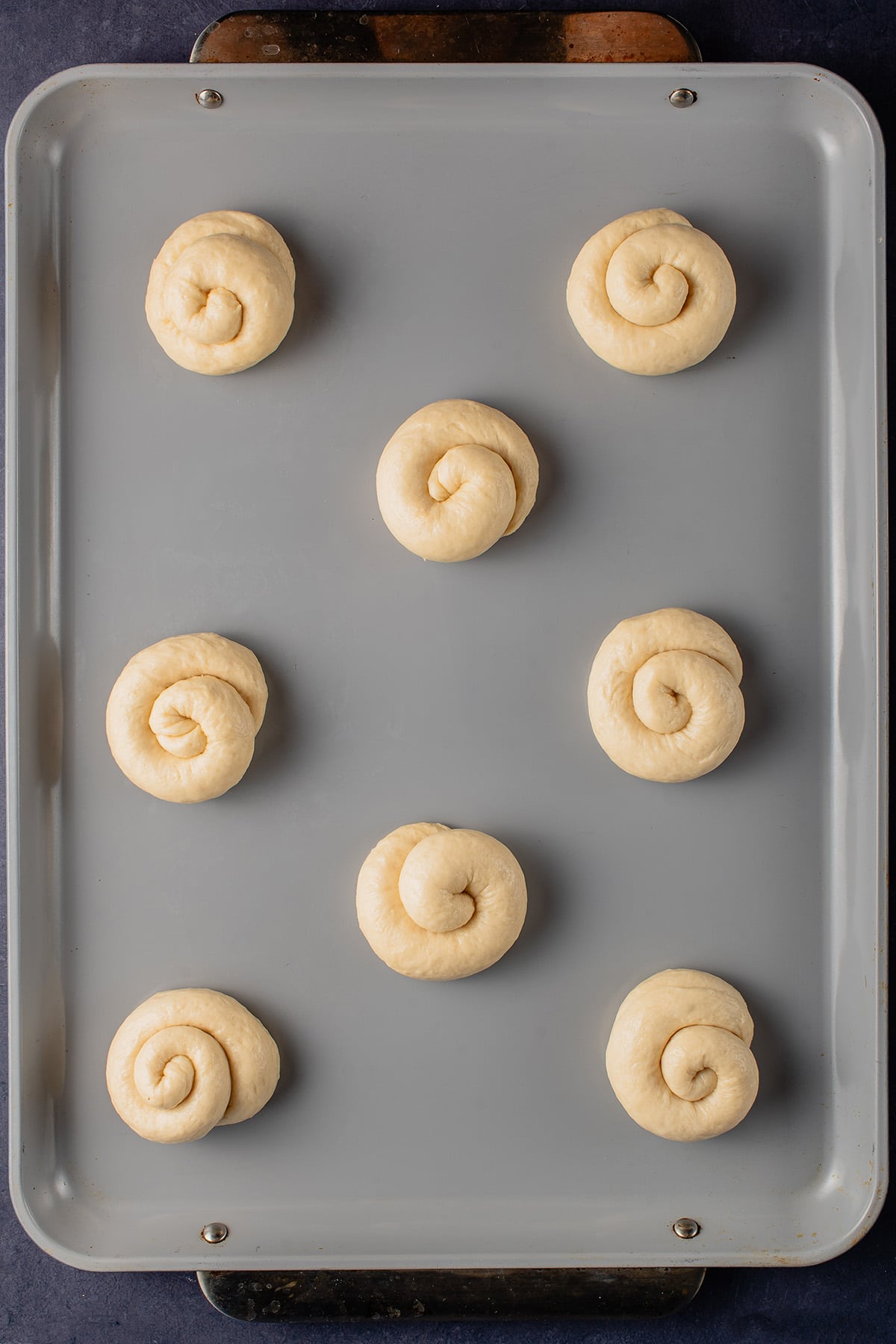 unbaked ensaymada on baking sheet