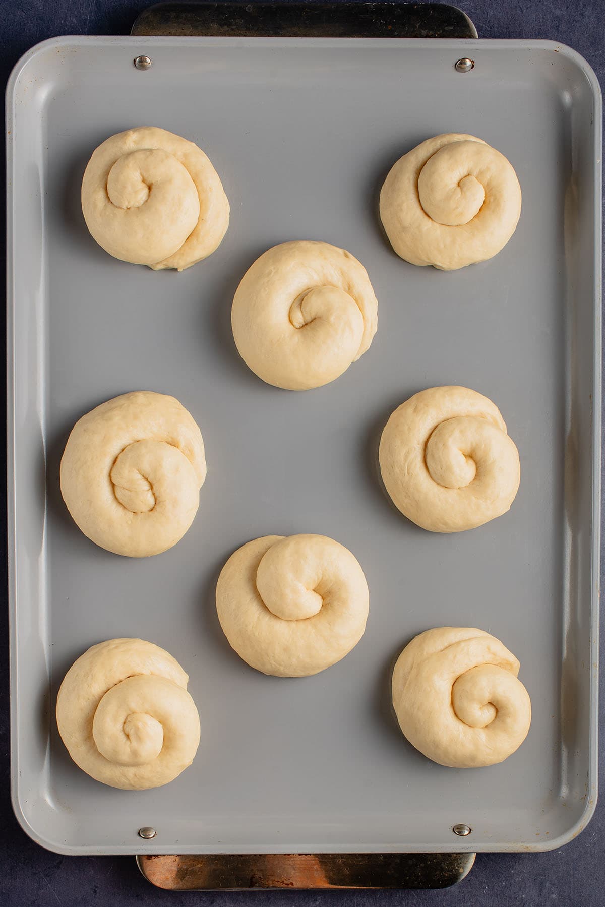 unbaked ensaymada on baking sheet