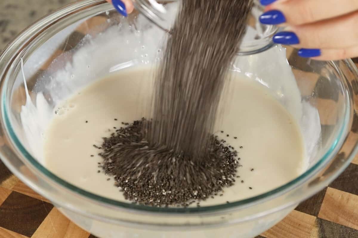 making vegan chia seed pudding with yogurt in large glass bowl