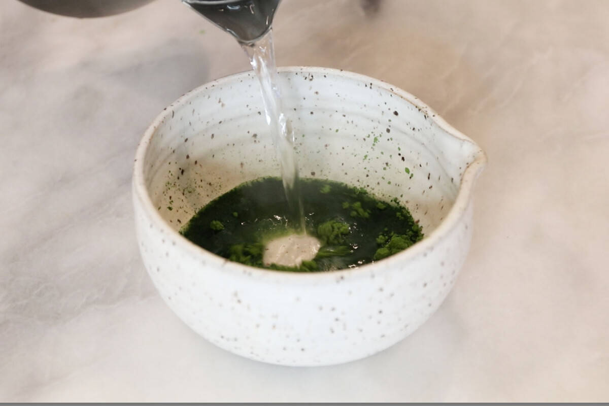 adding hot water to bowl of matcha