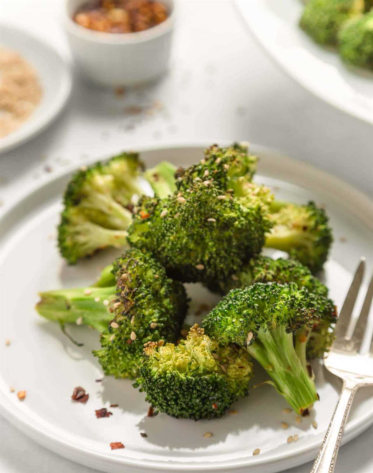 air fried broccoli on a white plate with a fork on the side