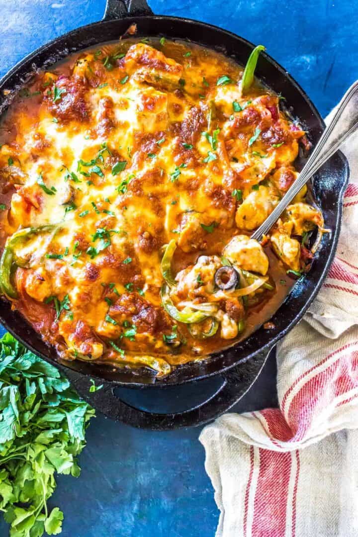 Keto Pizza Casserole in cast iron skillet on blue board